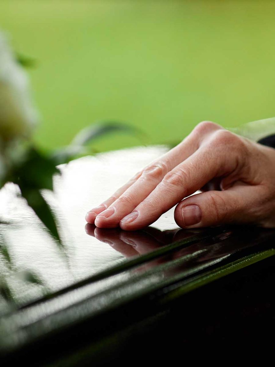 closeup-of-womans-hand-on-coffin-2023-11-27-04-55-58-utc.jpg